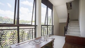 A balcony with a wooden table, metal railings, and a staircase. - Hotel O Anika Guest House (Tuban)
