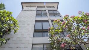 A modern hotel building with a tiled facade, multiple windows, and a sign indicating it is a hotel. - Hotel O Anika Guest House (Tuban)