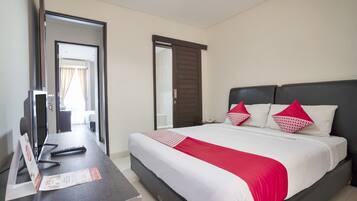 A hotel room with a bed, a desk, and a mirror.