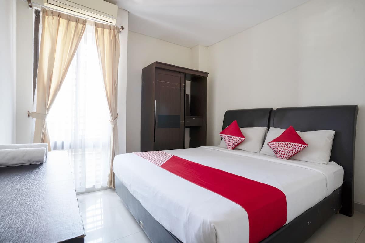 Une chambre d’hôtel avec un lit, une armoire et un bureau.