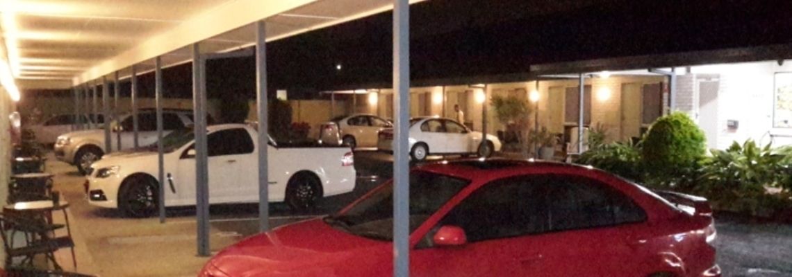 Een parkeergarage met meerdere auto's die onder een afdak staan.