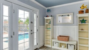 A room with a pool view, white shelving, and a starfish decoration.