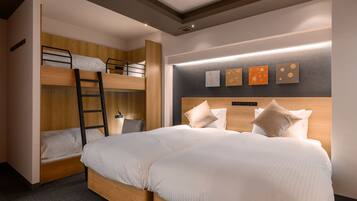 A modern hotel room with a bunk bed, a separate bed, and a headboard with built-in lighting.
