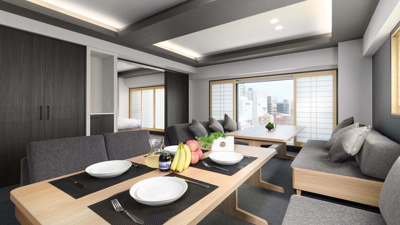 Un comedor moderno con una mesa de madera, sofás grises y vistas a la ciudad.
