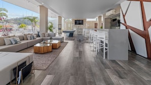 A spacious living area with a sofa, coffee table, and a TV mounted on the wall.