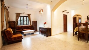 Una sala de estar con un sofá, una mesa de centro y una zona de comedor con una mesa y sillas.