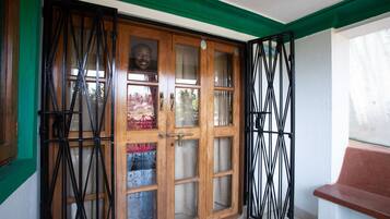 Una puerta de madera con paneles de vidrio y una reja de metal.