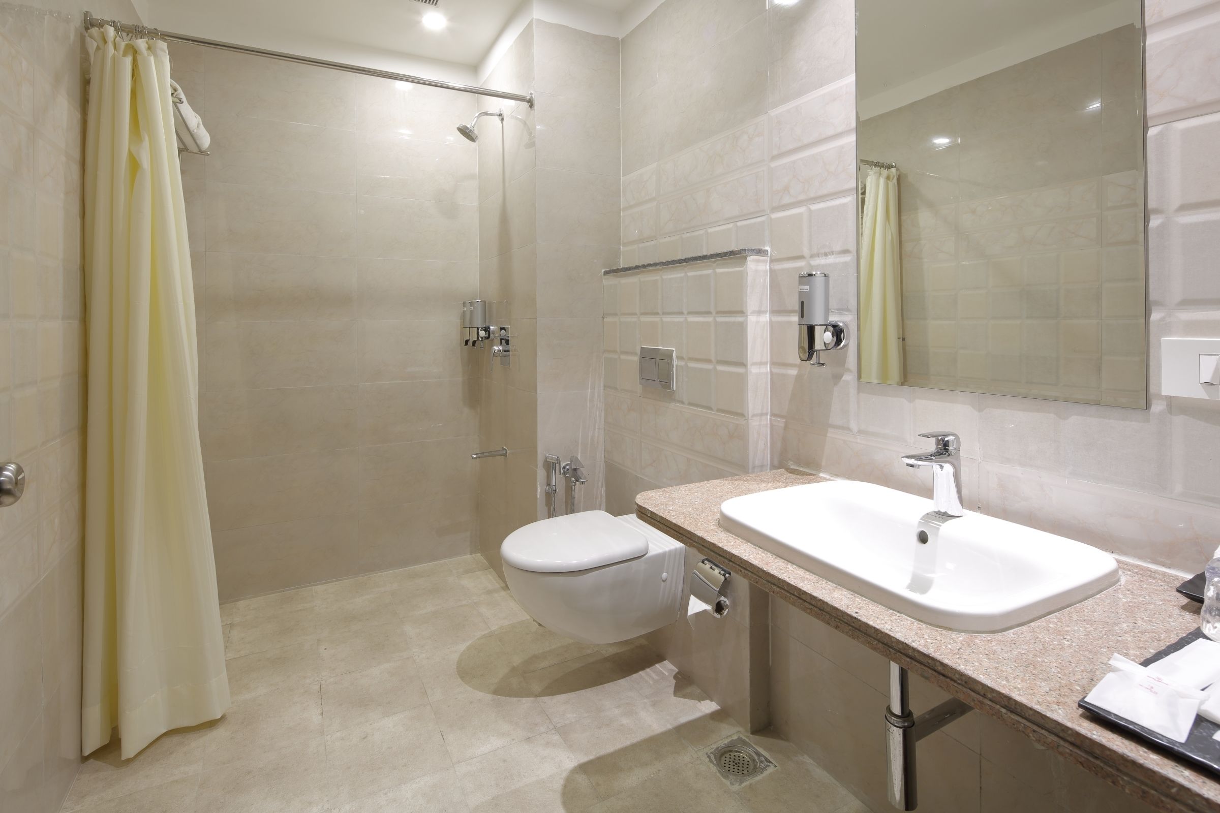A modern bathroom with a shower, toilet, and sink.
