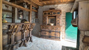 Une cuisine rustique avec des armoires en bois, un mur en pierre et une porte verte.