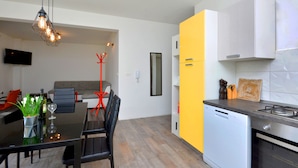 Una cocina moderna con lavavajillas, estufa y comedor con mesa y sillas.