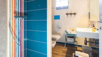 Un baño con ducha, inodoro, lavamanos y armario.