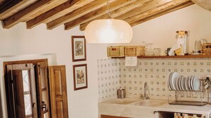 A rustic dining area with a wooden table, chairs, and a hanging light fixture. - Small Apartment With Independent Access  In Beautiful Tuscan Farmhouse (Castelnuovo Berardenga)
