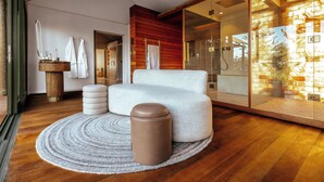Un baño moderno con un tocador de madera, un tapete redondo y un espejo grande.