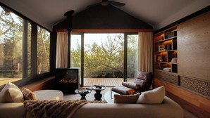Una sala de estar acogedora con chimenea, un sofá de cuero, una mesa de centro y una estantería.