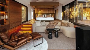 Un dormitorio moderno con una cama grande, un sofá, una mesita de centro y un televisor.