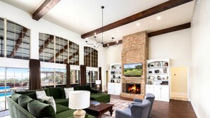 A spacious living room with a fireplace, large windows, and a pool view. - Experience Vista Grande: 4600 sq ft. of Luxury - Heatable Pool and City Views (Helotes)