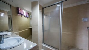 Chuveiro, chinelos, bidê, toalhas de banho