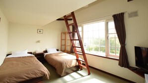 A room with two beds, a TV, and a window with curtains. - Niseko OAC Lodge (Niseko)