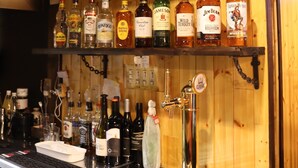 A bar area with shelves of various liquor bottles and a tap. - Niseko OAC Lodge (Niseko)