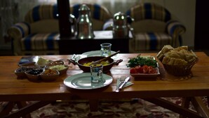 Uma mesa de jantar com diversos pratos, um copo e talheres.