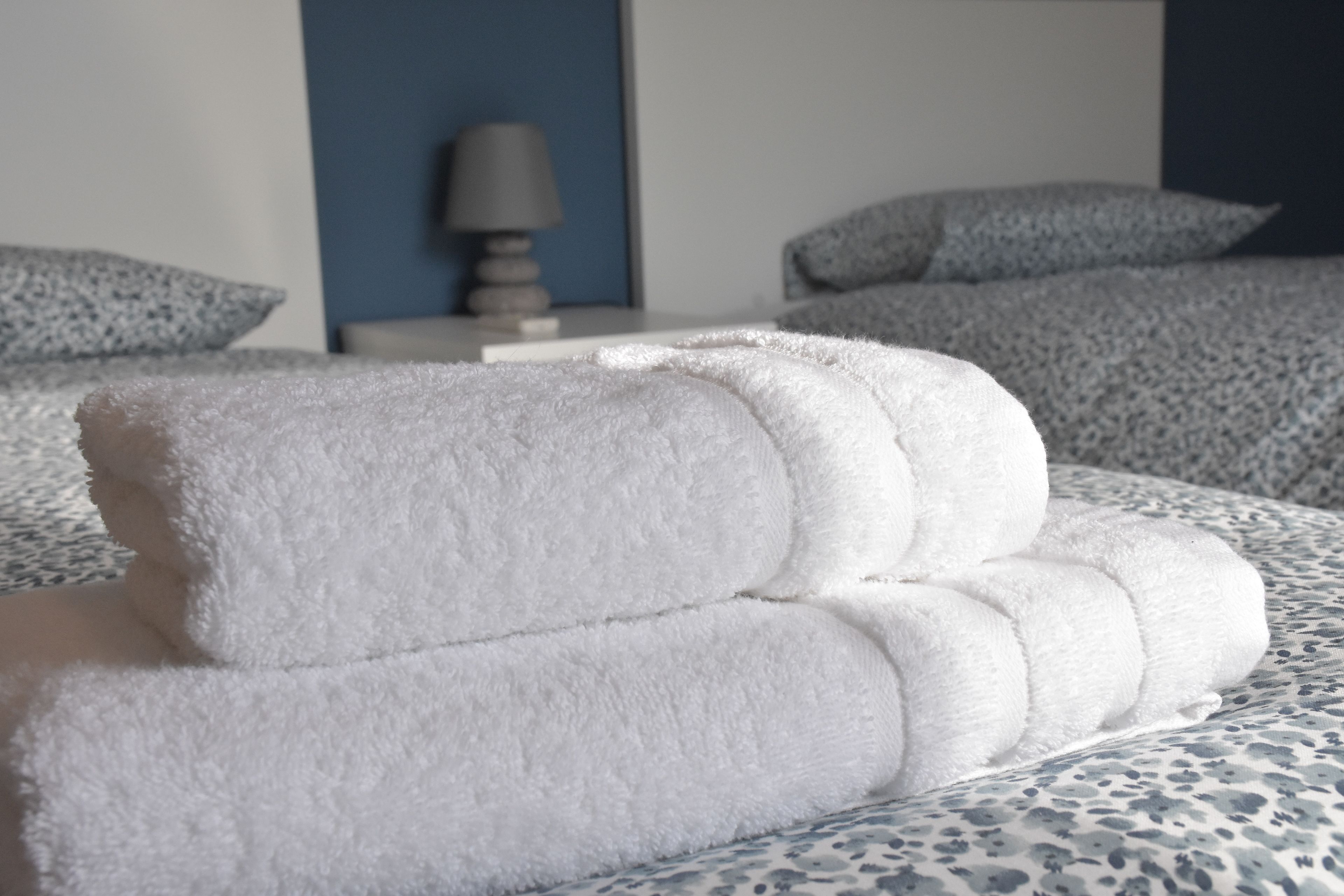 Una cama bien hecha con una colcha estampada y dos almohadas.