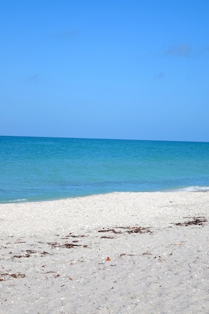A beach with clear blue water and white sand.