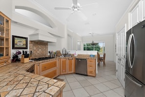 A spacious kitchen with a large island, stainless steel appliances, and a dining area with a view.
