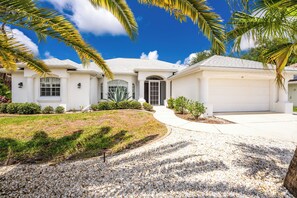 A two-story house with a garage, a driveway, and a well-maintained lawn.