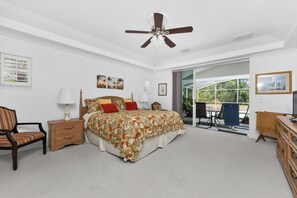 A bedroom with a bed, nightstand, chair, dresser, and a ceiling fan. - WATERFRONT, HEATED POOL, 3/2/2  single-family Rotonda West Home (Rotonda West)