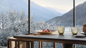 A dining table with a plate of food and a glass, set against a backdrop of snow-covered trees and mountains. - Lefay Resort & SPA Dolomiti (Pinzolo)