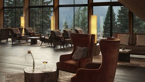A spacious lobby with large windows, wooden beams, and modern seating arrangements. - Lefay Resort & SPA Dolomiti (Pinzolo)