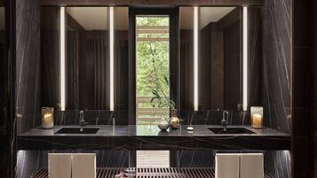 A modern bathroom with two sinks, a large mirror, and a wooden bench.