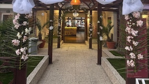 A hotel entrance with a covered walkway, potted plants, and a sign for 'bach club.' - Beach Club Ippocampo (Manfredonia)
