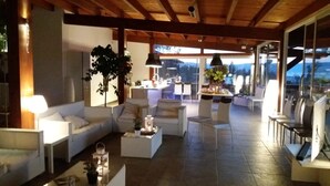 A spacious living area with a high ceiling, modern furniture, and a view of the outdoors. - Beach Club Ippocampo (Manfredonia)
