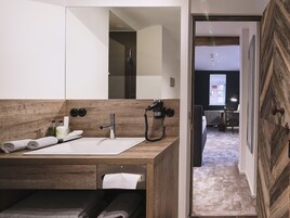 Un baño moderno con tocador de madera, un espejo grande y un secador de pelo.