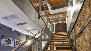 A modern staircase with a metal railing, wooden steps, and exposed wooden beams. - Bachofer (Waiblingen)