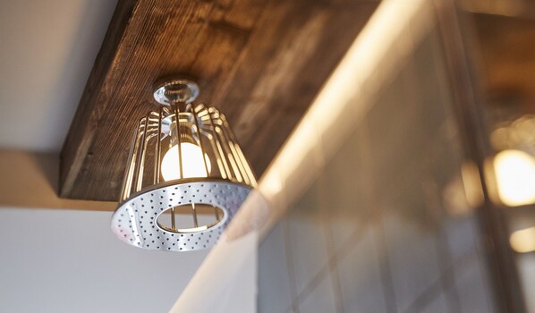 A close-up of a wooden ceiling with a metal light fixture. - Bachofer (Waiblingen)