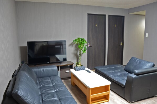 Apartamento, várias camas | Sala de estar | TV de tela plana