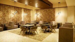 Eine moderne Lounge mit verschiedenen Sitzgelegenheiten, darunter Tische und Stühle, sowie dekorativen Wandverkleidungen.