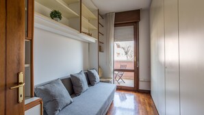 A compact living space with a sofa, a small table, and a potted plant.