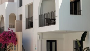 A modern multi-story building with white facades, arched balconies, and black railings. - Nami Hotel & Suites (Hersonissos)