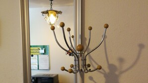 Een spiegel toont een kamer met een kitchenette, een magnetron, een koelkast en een stoel.