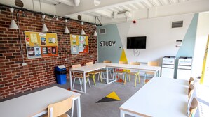 A study area with white tables, chairs, and a bulletin board with various notices. - Popup Bath (Bath)