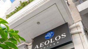 Un edificio con un cartel que dice 'AELOS SUITES'.
