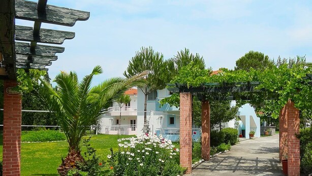 A pathway leading to a building with a brick archway and a pergola. - Chroma Studios (Istiaia-Aidipsos)