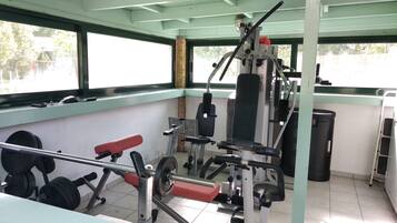 A gym with weightlifting equipment, benches, and a punching bag.