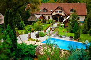 A large house with a swimming pool, surrounded by lush greenery and a well-maintained garden. - Aranygombos Fogadó (Telkibánya)