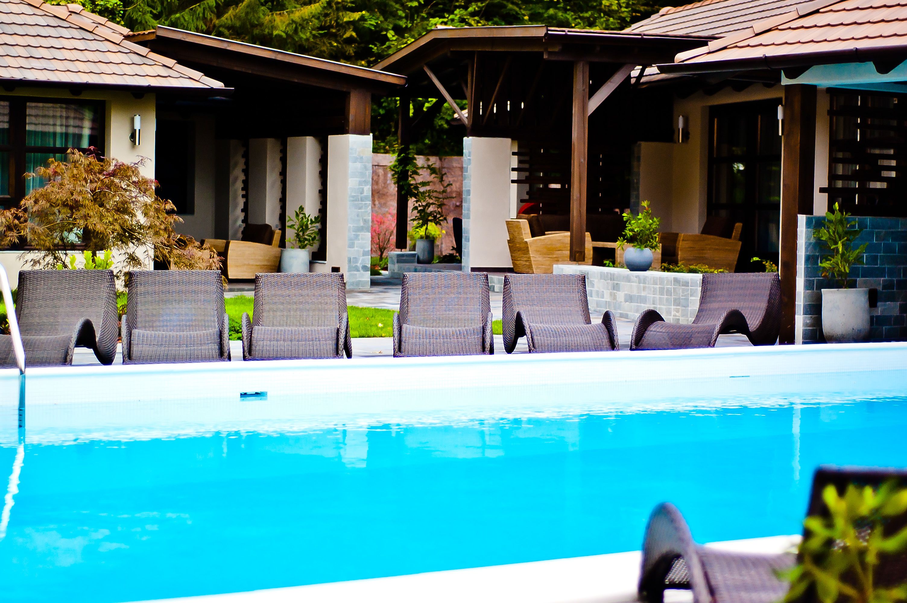 A poolside area with lounge chairs and a covered seating area.