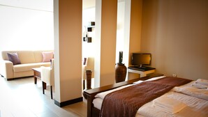 Una habitación de hotel con cama, televisor, sofá y una mesa de centro.