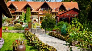 Un hotel de estilo chalete tradicional con varios balcones y un jardín bien cuidado.